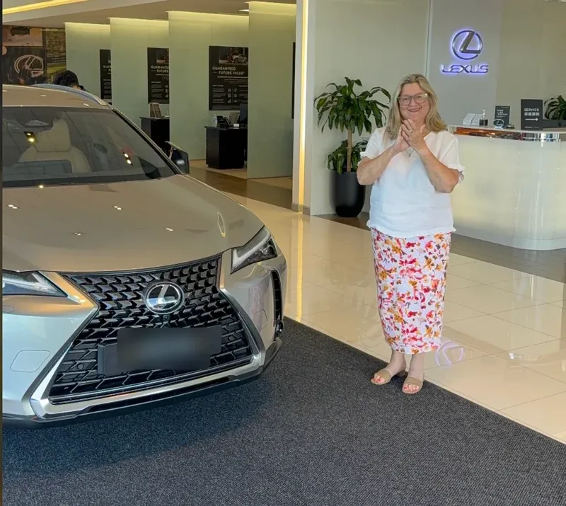 Customer celebrating her new Lexus UX at the dealership, financed through Simple Loans